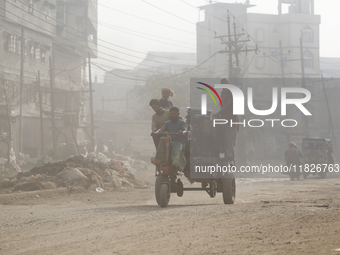 Residents make their way amid unhealthy air quality in Dhaka, Bangladesh, on December 1, 2024. (