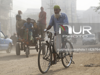 Residents make their way amid unhealthy air quality in Dhaka, Bangladesh, on December 1, 2024. (