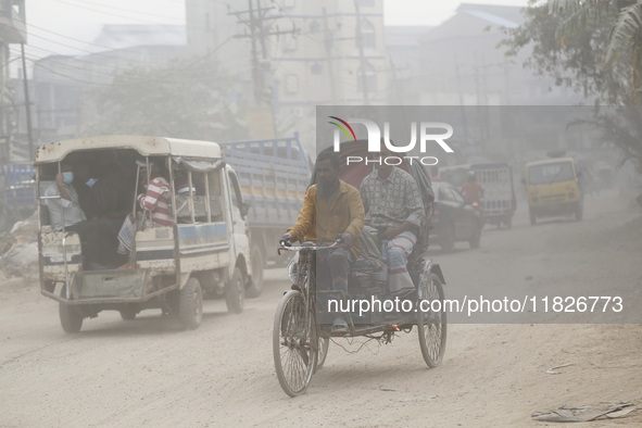 Commuters make their way amid unhealthy air quality in Dhaka, Bangladesh, on December 1, 2024. 