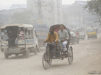 Commuters make their way amid unhealthy air quality in Dhaka, Bangladesh, on December 1, 2024. (