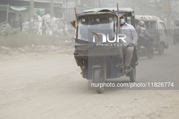 Commuters make their way amid unhealthy air quality in Dhaka, Bangladesh, on December 1, 2024. 