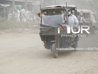 Commuters make their way amid unhealthy air quality in Dhaka, Bangladesh, on December 1, 2024. (