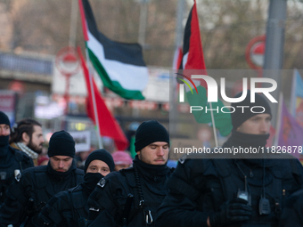 Police walk alongside protesters as more than a hundred pro-Palestinian protesters participate in a demonstration against the German governm...