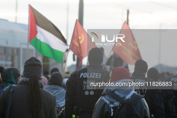 Police walk alongside protesters as more than a hundred pro-Palestinian protesters participate in a demonstration against the German governm...