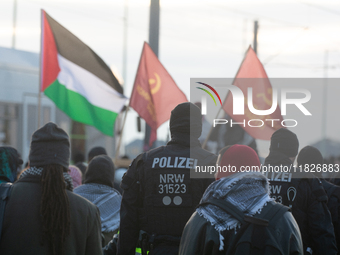 Police walk alongside protesters as more than a hundred pro-Palestinian protesters participate in a demonstration against the German governm...