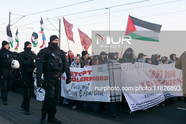 Police walk alongside protesters as more than a hundred pro-Palestinian protesters participate in a demonstration against the German governm...