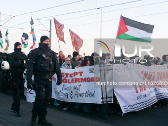 Police walk alongside protesters as more than a hundred pro-Palestinian protesters participate in a demonstration against the German governm...