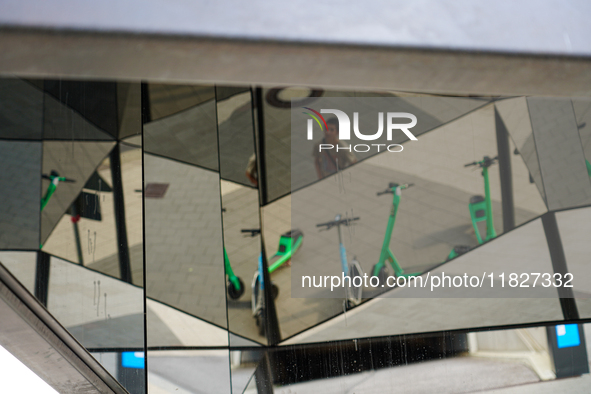 Geometric reflections of parked rental e-scooters appear in a pedestrian zone in Hamburg, Germany, on August 26, 2022. The photo shows the r...