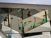 Geometric reflections of parked rental e-scooters appear in a pedestrian zone in Hamburg, Germany, on August 26, 2022. The photo shows the r...