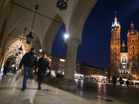 KRAKOW, POLAND - DECEMBER 01:   
A couple of visitors walks in a quiet corner of Krakow's UNESCO-listed Market Square contrasts with the bus...