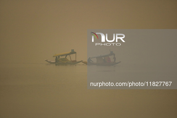 Men row boats in the waters of Dal Lake amid fog in Srinagar, Jammu and Kashmir, on December 02, 2024. Weather experts warn of heavy snowfal...