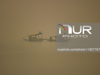 Men row boats in the waters of Dal Lake amid fog in Srinagar, Jammu and Kashmir, on December 02, 2024. Weather experts warn of heavy snowfal...