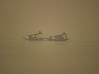 Men row boats in the waters of Dal Lake amid fog in Srinagar, Jammu and Kashmir, on December 02, 2024. Weather experts warn of heavy snowfal...