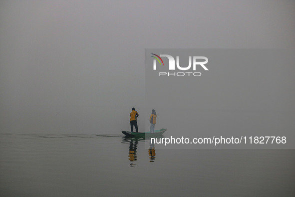 A man rows a boat in the waters of Dal Lake amid fog in Srinagar, Jammu and Kashmir, on December 02, 2024. Weather experts warn of heavy sno...