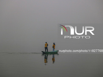 A man rows a boat in the waters of Dal Lake amid fog in Srinagar, Jammu and Kashmir, on December 02, 2024. Weather experts warn of heavy sno...