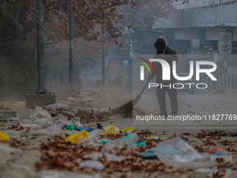 A worker sweeps along the roadside in Srinagar, Jammu and Kashmir, on December 02, 2024. Weather experts warn of heavy snowfall and a harsh...