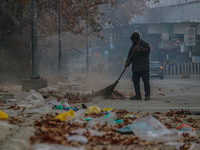 A worker sweeps along the roadside in Srinagar, Jammu and Kashmir, on December 02, 2024. Weather experts warn of heavy snowfall and a harsh...