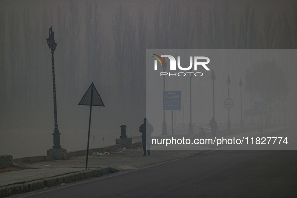 People jog on the banks of Dal Lake amid fog in Srinagar, Jammu and Kashmir, on December 02, 2024. Weather experts warn of heavy snowfall an...