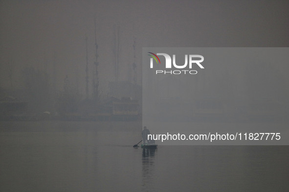 A man rows a boat in the waters of Dal Lake amid fog in Srinagar, Jammu and Kashmir, on December 02, 2024. Weather experts warn of heavy sno...