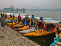 A man walks on the banks of Dal Lake amid fog in Srinagar, Jammu and Kashmir, on December 02, 2024. Weather experts warn of heavy snowfall a...