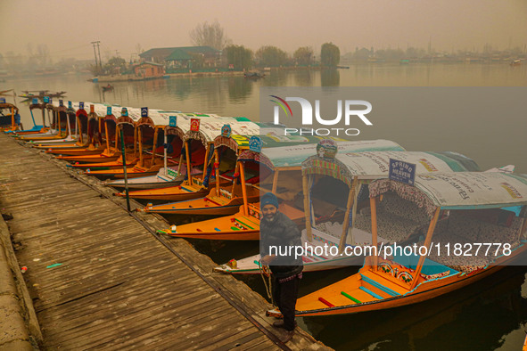 A man stands on the banks of Dal Lake amid fog in Srinagar, Jammu and Kashmir, on December 02, 2024. Weather experts warn of heavy snowfall...