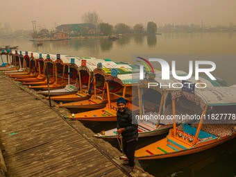 A man stands on the banks of Dal Lake amid fog in Srinagar, Jammu and Kashmir, on December 02, 2024. Weather experts warn of heavy snowfall...