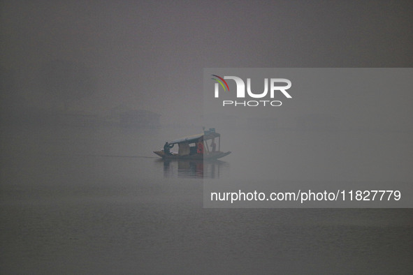 A man rows a boat in the waters of Dal Lake amid fog in Srinagar, Jammu and Kashmir, on December 02, 2024. Weather experts warn of heavy sno...