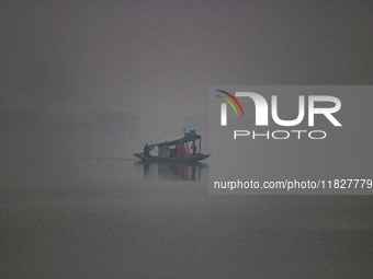 A man rows a boat in the waters of Dal Lake amid fog in Srinagar, Jammu and Kashmir, on December 02, 2024. Weather experts warn of heavy sno...