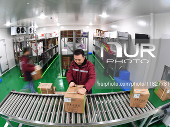 A worker at a cold storage for smart vaccines takes stock of vaccines on the shelves in Guiyang, Guizhou province, China, on December 2, 202...