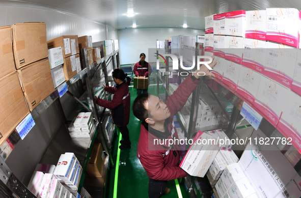 A staff member of a cold storage for smart vaccines takes stock of vaccines on shelves in Guiyang, China, on December 2, 2024. 