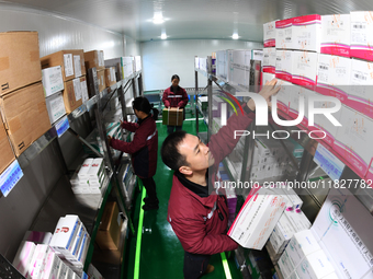 A staff member of a cold storage for smart vaccines takes stock of vaccines on shelves in Guiyang, China, on December 2, 2024. (