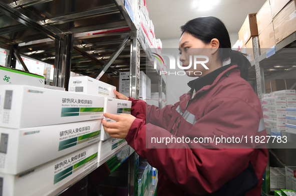 A staff member of a cold storage for smart vaccines takes stock of vaccines on shelves in Guiyang, China, on December 2, 2024. 