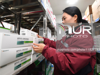 A staff member of a cold storage for smart vaccines takes stock of vaccines on shelves in Guiyang, China, on December 2, 2024. (