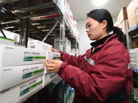 A staff member of a cold storage for smart vaccines takes stock of vaccines on shelves in Guiyang, China, on December 2, 2024. (