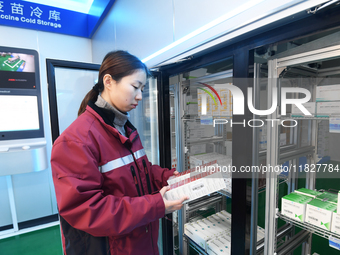 A staff member at a cold storage for smart vaccines checks vaccine information in Guiyang, China, on December 2, 2024. (