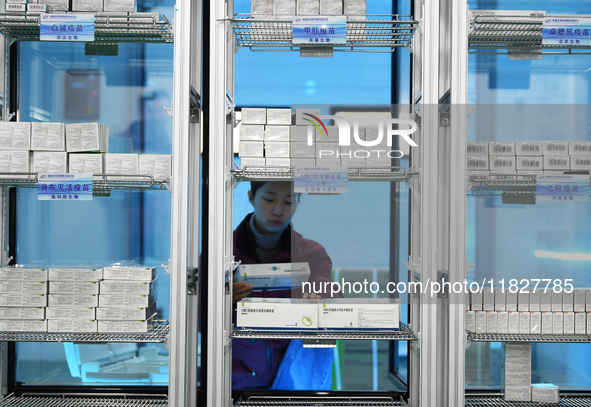 A staff member at a cold storage for smart vaccines checks vaccine information in Guiyang, China, on December 2, 2024. 