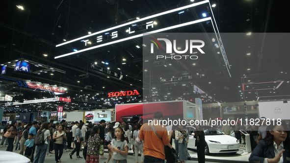 Visitors inspect Tesla cars displayed at the Thailand International Motor Expo 2024 at the IMPACT exhibition center in Bangkok, Thailand, on...