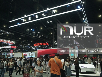 Visitors inspect Tesla cars displayed at the Thailand International Motor Expo 2024 at the IMPACT exhibition center in Bangkok, Thailand, on...