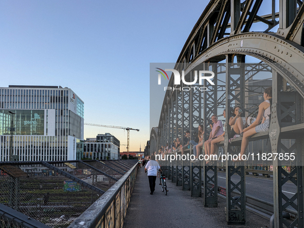 Young people gather on the Hackerbrucke in Munich, Bavaria, to view the sunset. This iconic bridge, which connects the central bus station (...