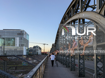 Young people gather on the Hackerbrucke in Munich, Bavaria, to view the sunset. This iconic bridge, which connects the central bus station (...