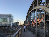 Young people gather on the Hackerbrucke in Munich, Bavaria, to view the sunset. This iconic bridge, which connects the central bus station (...