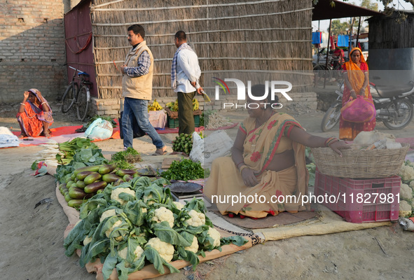 A woman sells vegetables at a temporary open-air market and waits for customers in Samastipur, India on november 29, 2024.