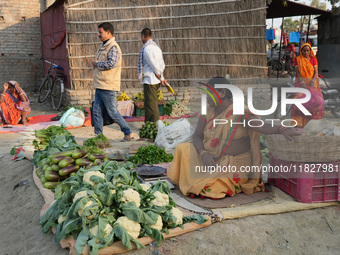 A woman sells vegetables at a temporary open-air market and waits for customers in Samastipur, India on november 29, 2024.(