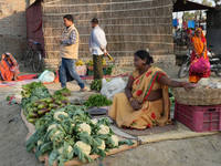 A woman sells vegetables at a temporary open-air market and waits for customers in Samastipur, India on november 29, 2024.(