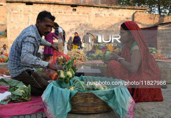 A couple sets up their vegetable shop at a temporary open-air market in Samastipur, Bihar, India. on november 29, 2024.