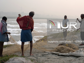 Fishermen prepare their fishing net on the bank of the Yamuna River, which is filled with toxic foam, in New Delhi, India, on November 7, 20...