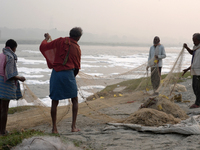 Fishermen prepare their fishing net on the bank of the Yamuna River, which is filled with toxic foam, in New Delhi, India, on November 7, 20...