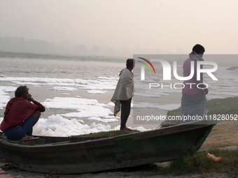 Fishermen sit on the bank of the Yamuna River filled with toxic foam in New Delhi, India, on November 7, 2024. (