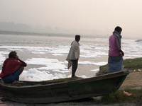 Fishermen sit on the bank of the Yamuna River filled with toxic foam in New Delhi, India, on November 7, 2024. (