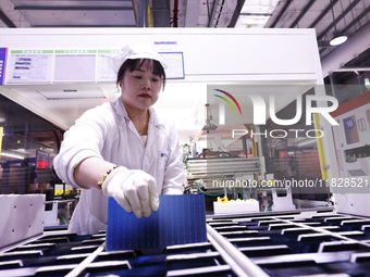 Workers produce export photovoltaic modules in a new energy 5G intelligent workshop in Suqian, China, on December 2, 2024. (